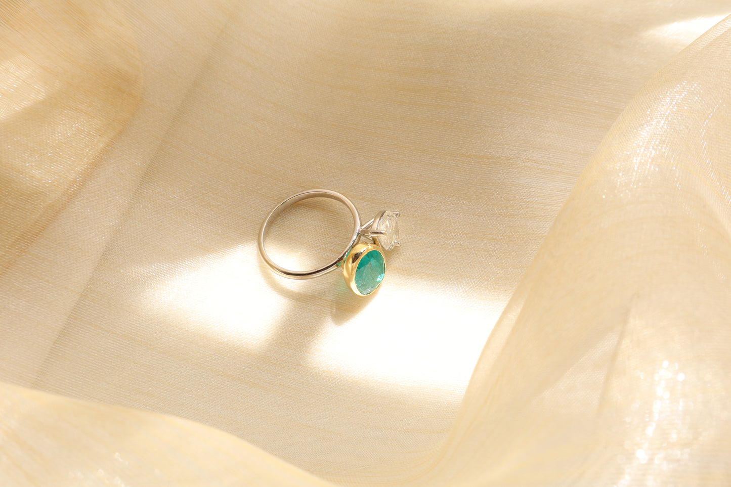 18K white gold ring featuring a pear-shaped lab-grown diamond and natural emerald, presented in eco-friendly packaging for a Singapore corporate