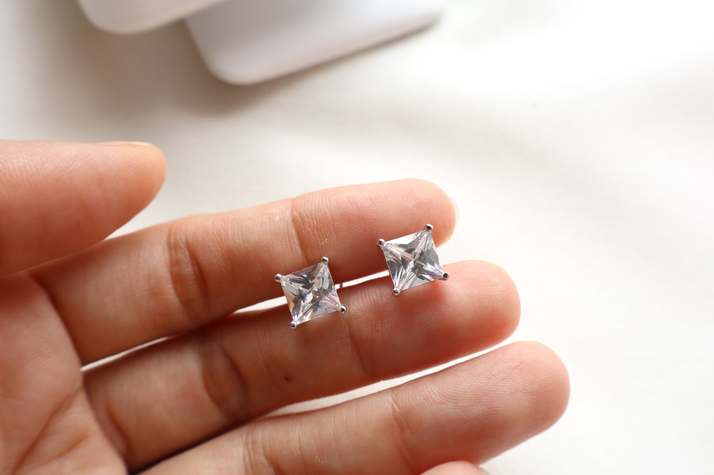 14K white gold stud earrings featuring 7mm princess cut Signity stones set in a sleek modern design, radiating brilliance. Sustainable jewelry packaging for Singapore corporate awards and bespoke fine jewelry.