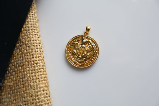 Custom family crest pendant crafted in silver plated in gold, featuring a personalized coat of arms within a 23mm round medallion. Handcrafted as a bespoke heirloom inspired by European heraldry.