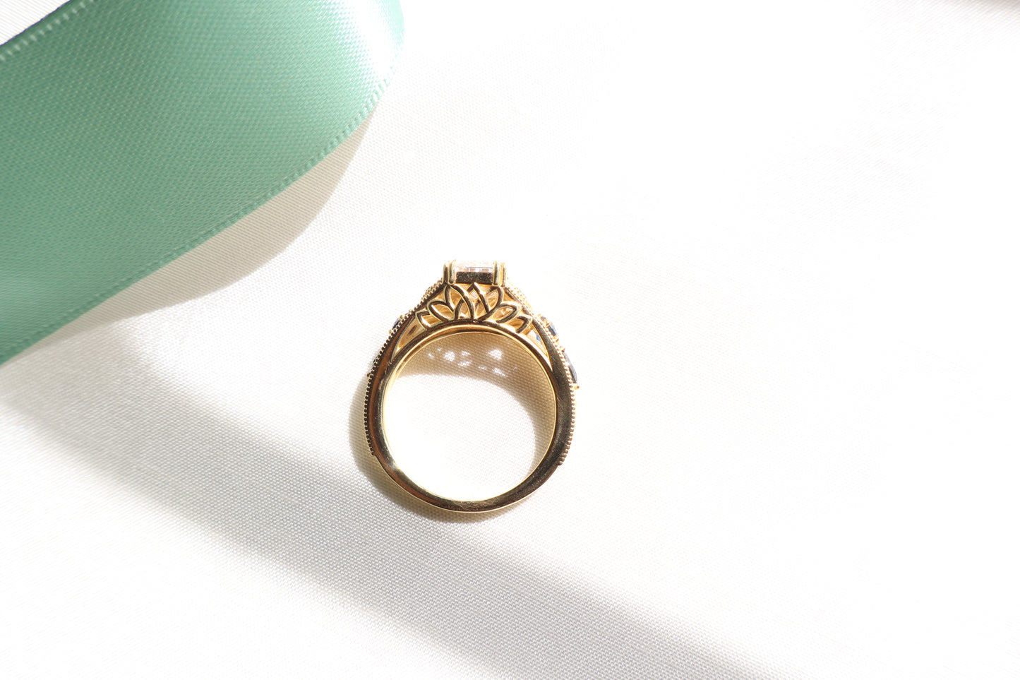 Custom 18K rose gold vintage-inspired engagement ring with intricate band detailing and elevated center stone, Singapore business milestone jewelry with eco packaging.