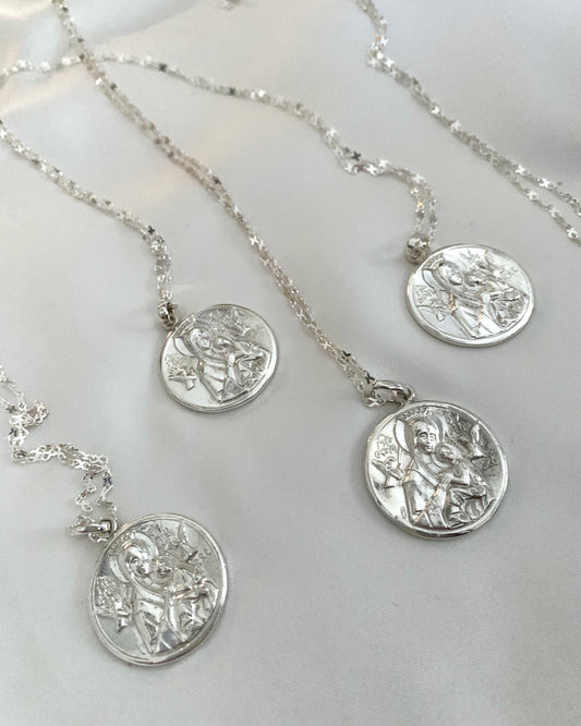 A round white gold pendant with the Our Lady of Perpetual Help.