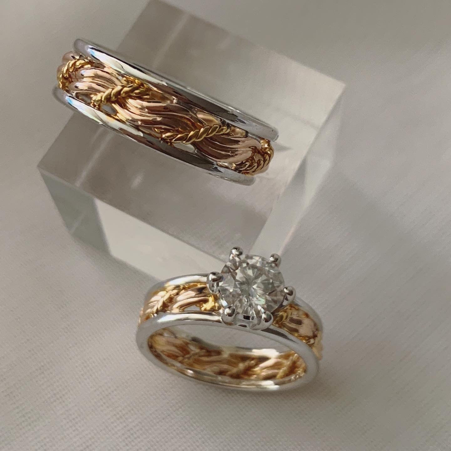Inspired by the "Cord of Three" bible verse. With three strands set in rose gold and its band set in white gold. For the bride's ring it has a 1 carat moissanite as its center stone.