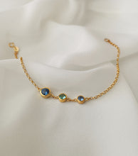 Load image into Gallery viewer, Aquamarine, blue topaz and blue sapphire as center stones of an 18k gold bracelet.

