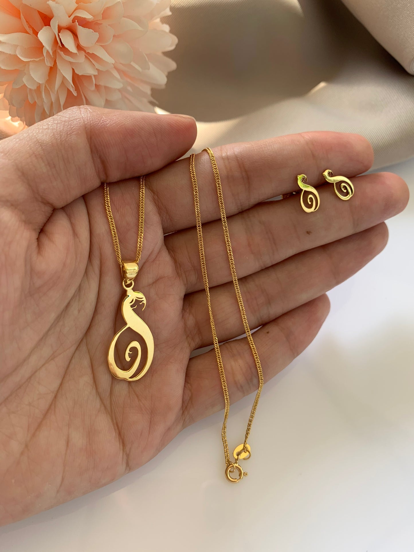 Mother and child love image on a paor of earrings and necklace. In yellow gold and white gold setting.