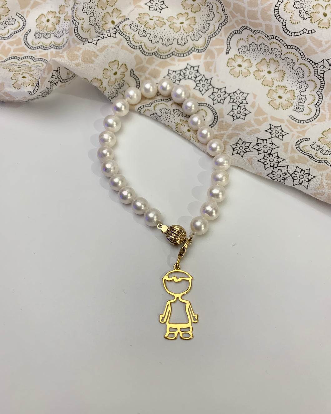 22 pieces of freshwater white pearls with a gold boy charm. Also with a ball clasp as its lock. 