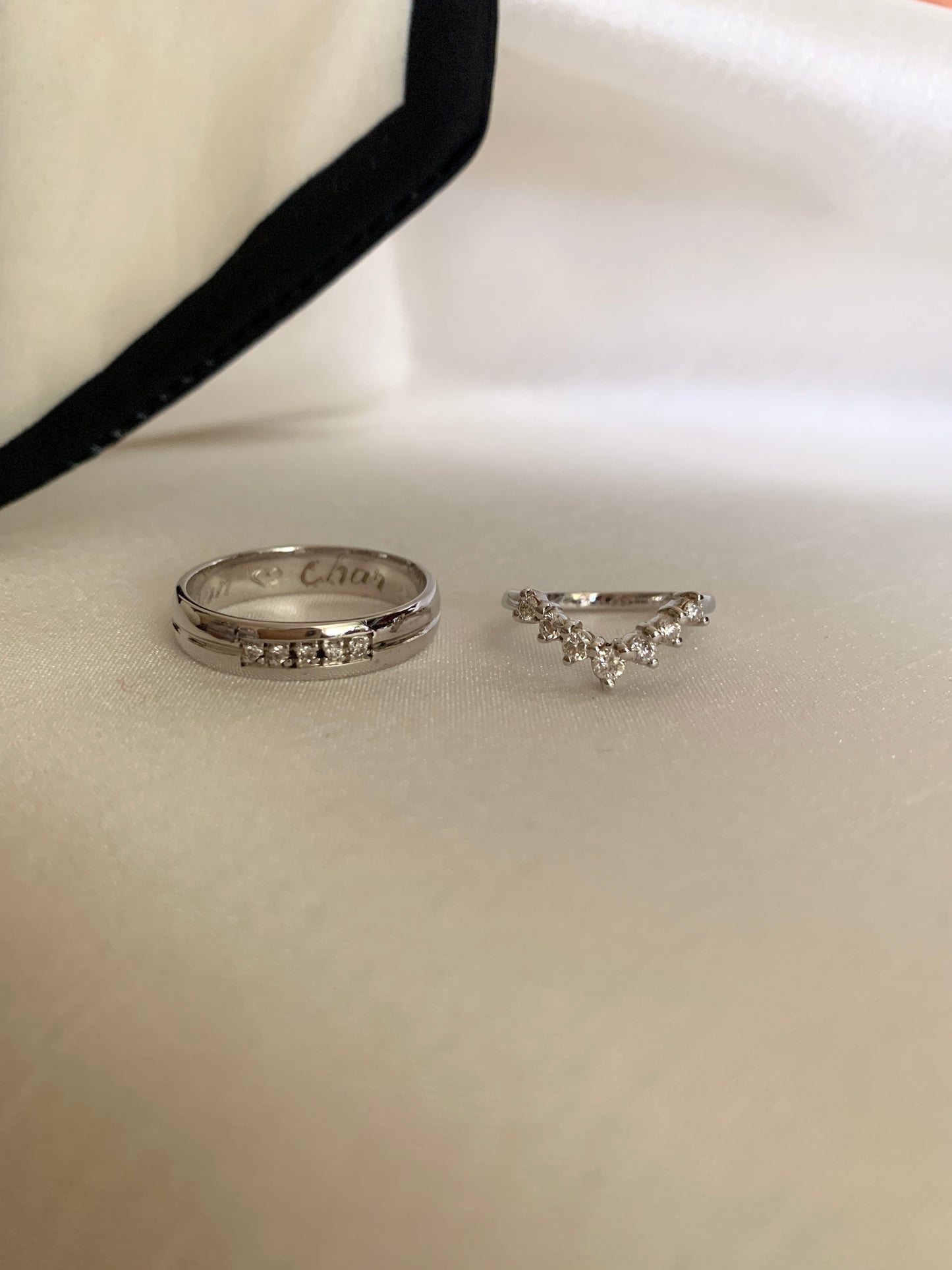7 small diamonds in a curved design set in white gold. Groom's ring: with 5 small diamonds at the center also in whitw gold.