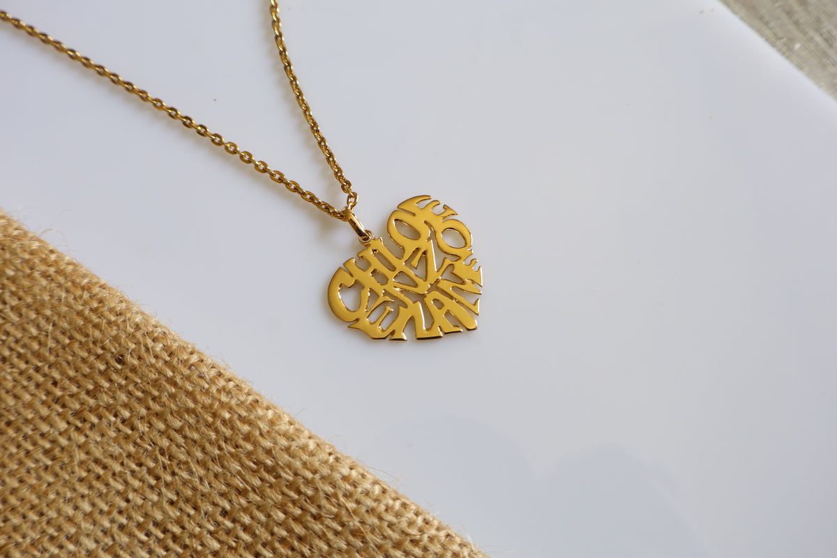 Handmade 14K gold custom heart name necklace with a personalized name cutout pendant, measuring 2.5cm x 2.5cm, displayed on a white surface.