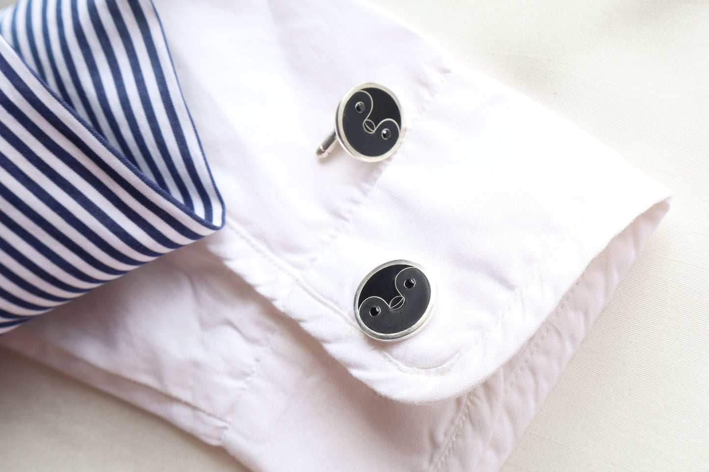 Custom 925 silver cufflinks with matte and glossy enamel and black onyx eyes, designed as a penguin face. A modern jewelry gift in Singapore with refined packaging.