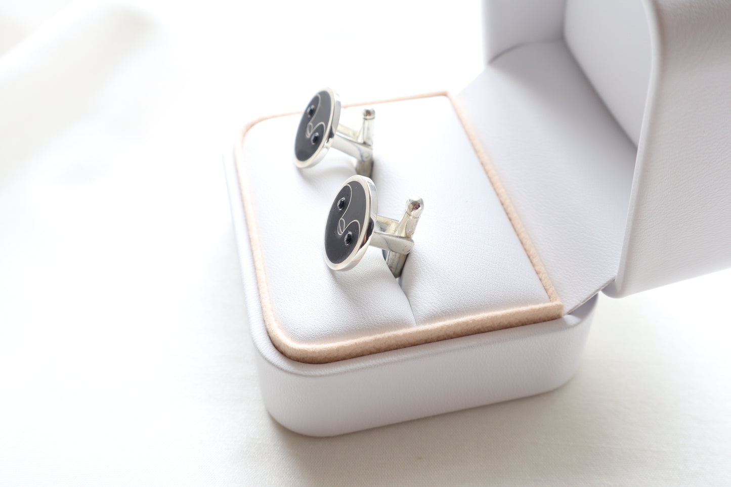 Custom 925 silver cufflinks with matte and glossy enamel and black onyx eyes, designed as a penguin face. A modern jewelry gift in Singapore with refined packaging.