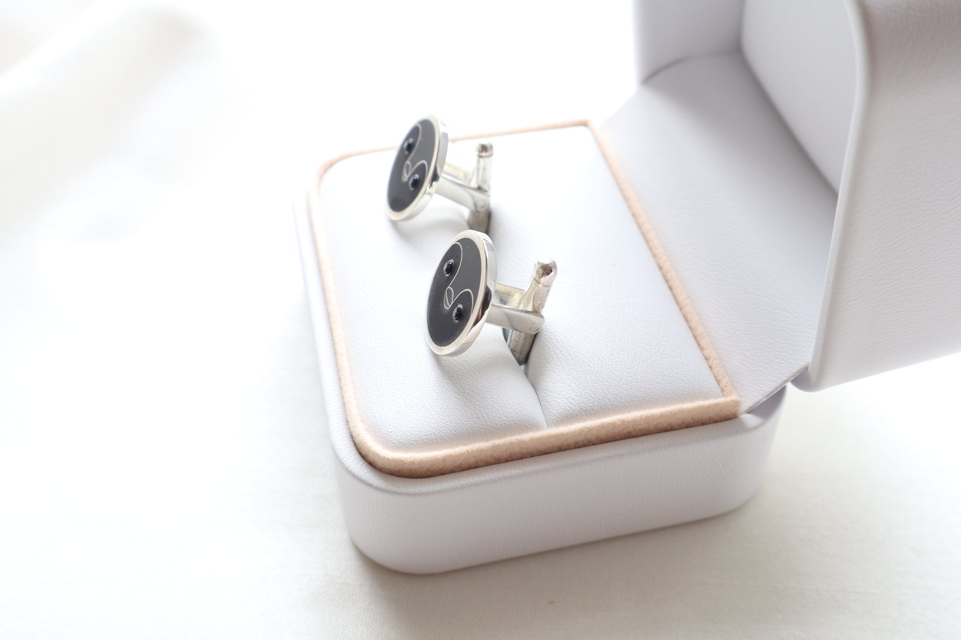 Custom 925 silver cufflinks with matte and glossy enamel and black onyx eyes, designed as a penguin face. A modern jewelry gift in Singapore with refined packaging.