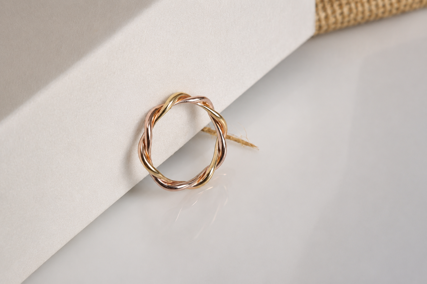Handcrafted 18K two-tone yellow gold and rose gold twisted ring with an elegant intertwined design. Bespoke jewelry by a Singapore jewelry supplier, ideal for premium corporate gifts and abaca packaging presentations.