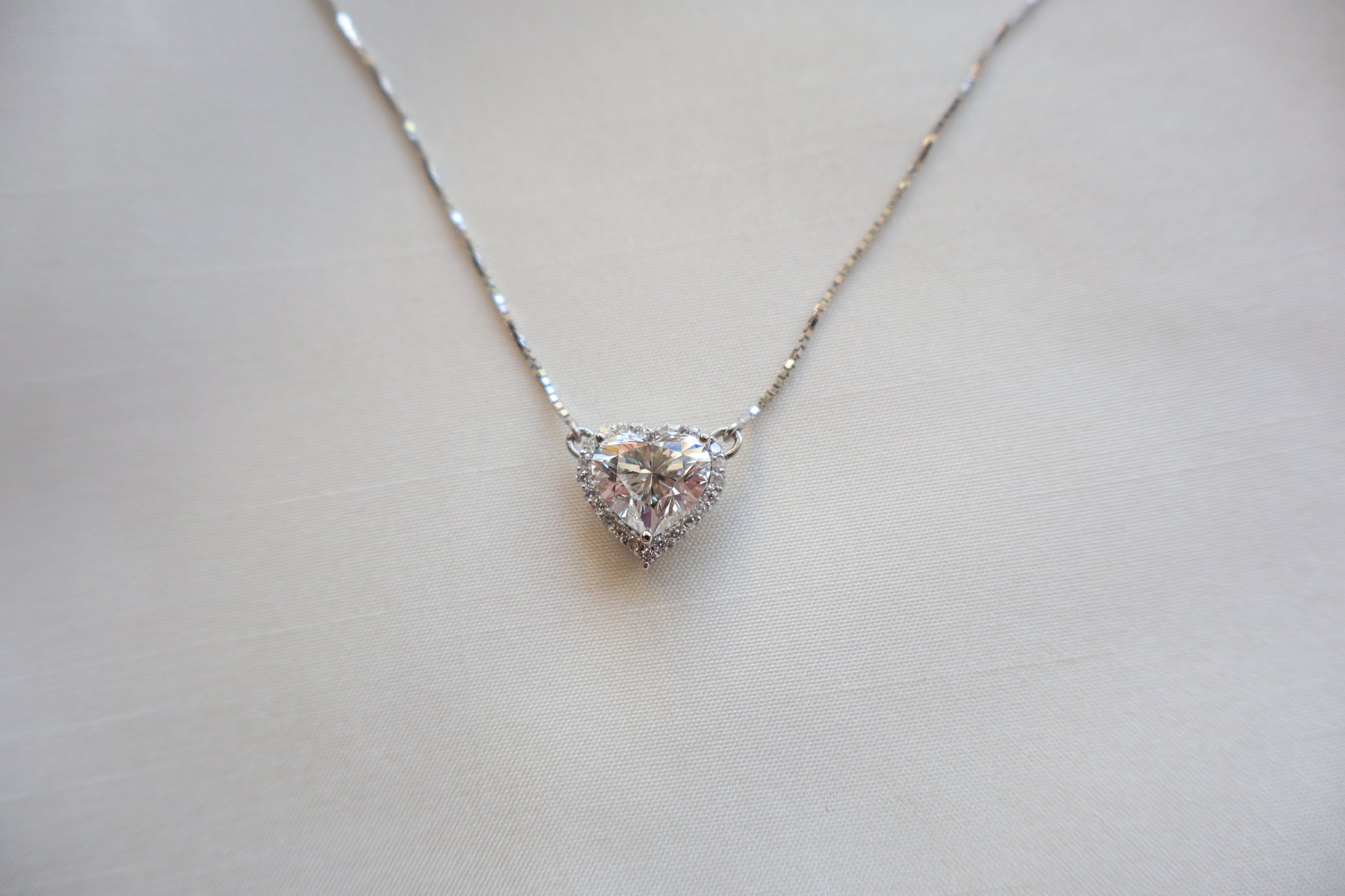 Heart-shaped 3 carat lab diamond halo pendant necklace on a fine chain — Eco-luxury abaca packaging with bespoke corporate recognition jewelry, customized design.