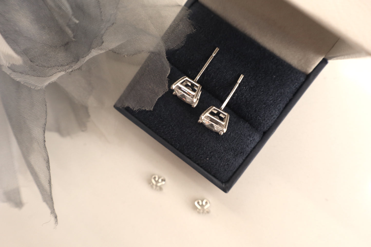 14K white gold stud earrings featuring 7mm princess cut Signity stones set in a sleek modern design, radiating brilliance. Sustainable jewelry packaging for Singapore corporate awards and bespoke fine jewelry.