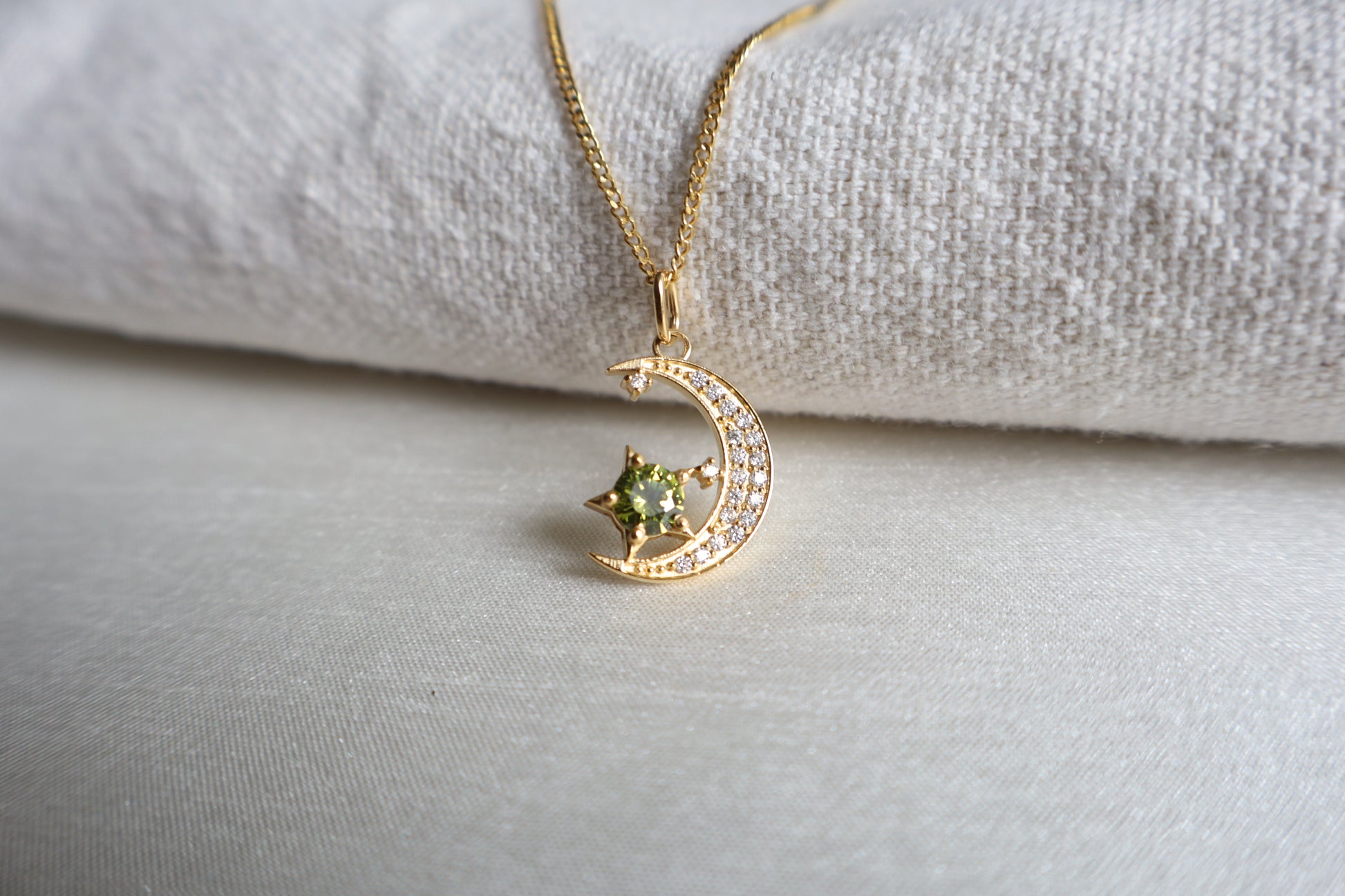 14-Karat Gold crescent moon pendant with peridot star and diamond accents. Designed in Singapore with luxury packaging, perfect for corporate gifts and client milestones.