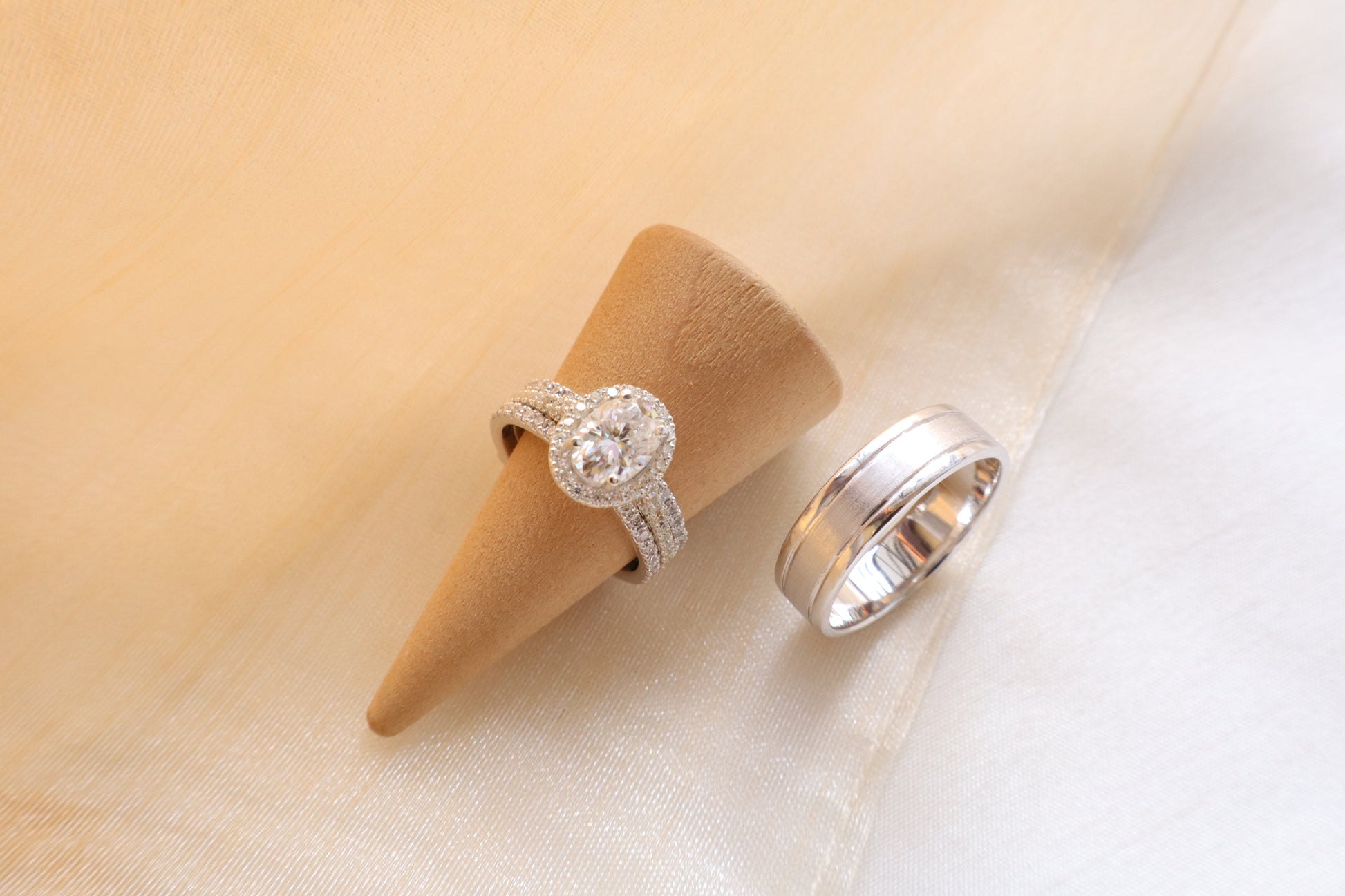 Custom gold bridal ring set with a moissanite engagement ring, diamond wedding band, and engraved groom’s ring, designed as a cohesive family heirloom. Eco-friendly abaca packaging. Singapore corporate jewelry.