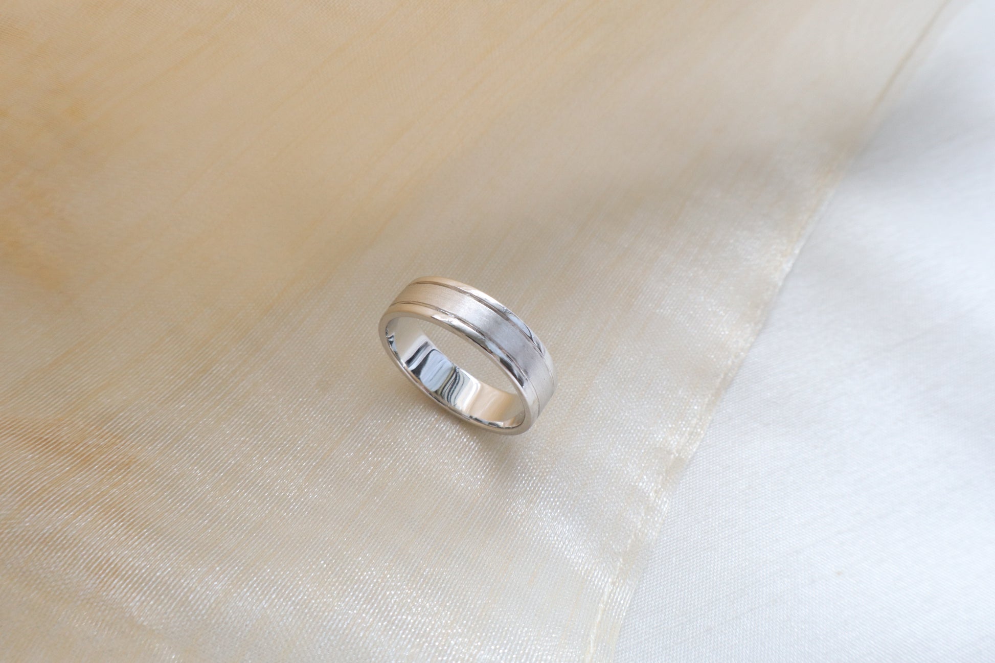 Custom gold bridal ring set with a moissanite engagement ring, diamond wedding band, and engraved groom’s ring, designed as a cohesive family heirloom. Eco-friendly abaca packaging. Singapore corporate jewelry.