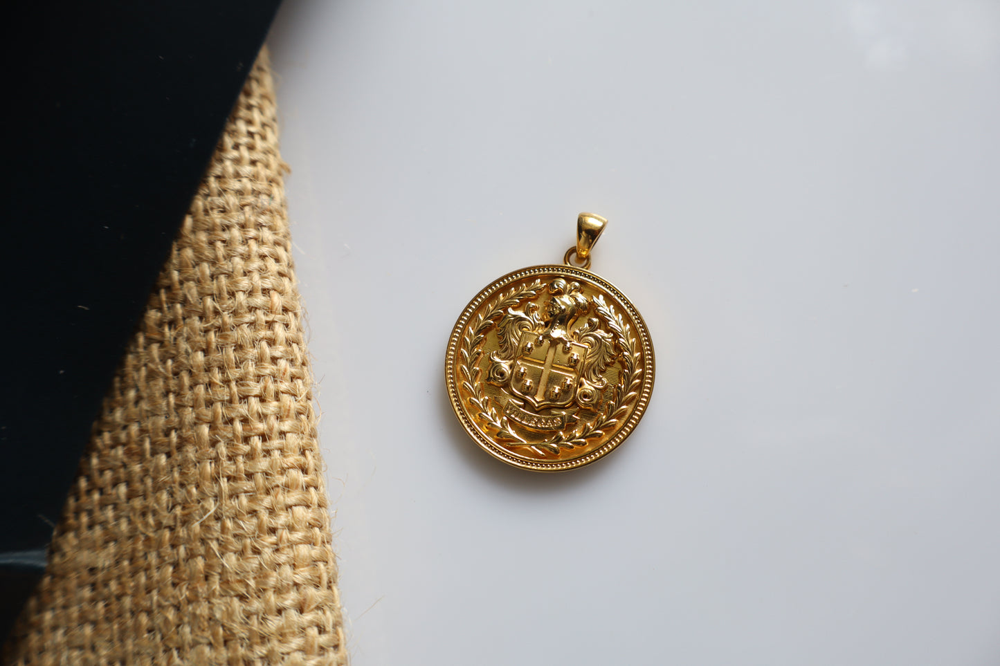 Custom family crest pendant crafted in silver plated in gold, featuring a personalized coat of arms within a 23mm round medallion. Handcrafted as a bespoke heirloom inspired by European heraldry.