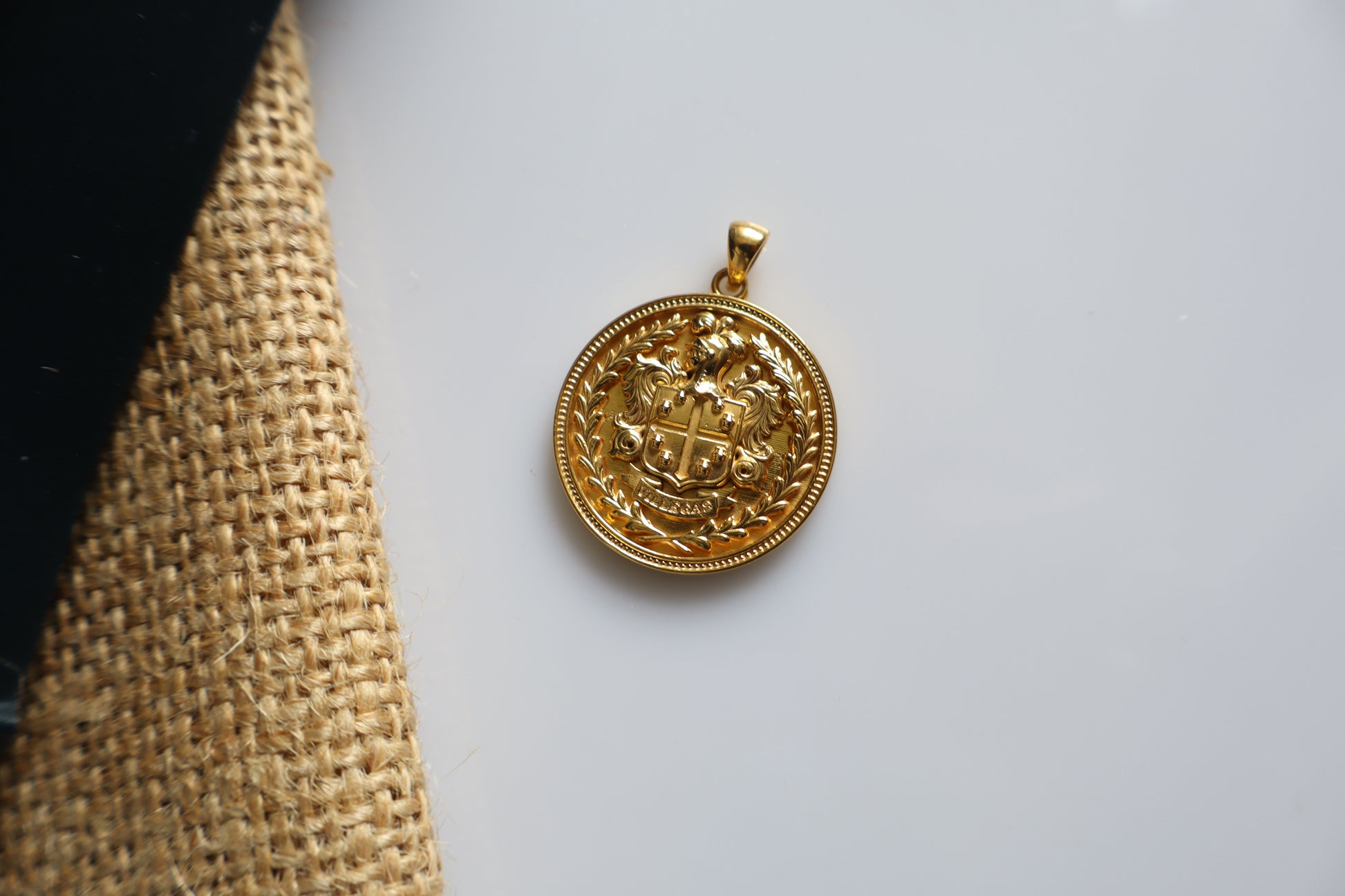 Custom family crest pendant crafted in silver plated in gold, featuring a personalized coat of arms within a 23mm round medallion. Handcrafted as a bespoke heirloom inspired by European heraldry.