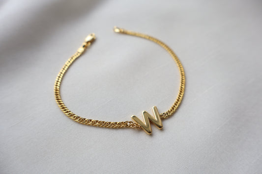 14K yellow gold bracelet with a polished reversible letter charm shaped as M or W on a fine chain, personalized sentimental gift jewelry.