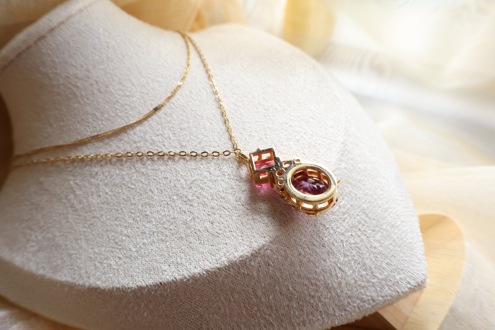 Custom necklace with an oval-cut alexandrite pendant accented by rubellite, ruby, blue sapphire, and natural diamonds on layered chains. Eco-friendly corporate gift jewelry in abaca packaging, bespoke design for Singapore companies.
