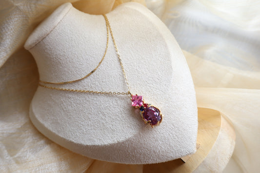 Custom necklace with an oval-cut alexandrite pendant accented by rubellite, ruby, blue sapphire, and natural diamonds on layered chains. Eco-friendly corporate gift jewelry in abaca packaging, bespoke design for Singapore companies.