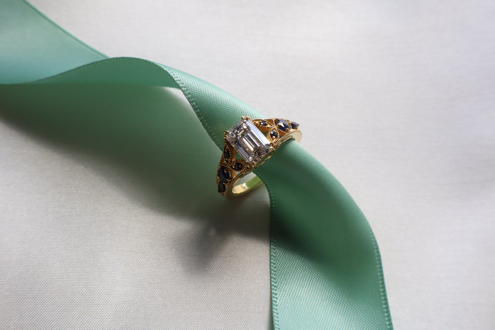 Custom 18K rose gold vintage-inspired engagement ring with intricate band detailing and elevated center stone, Singapore business milestone jewelry with eco packaging.