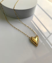 Load image into Gallery viewer, A gold heart pendant with shiny round diamonds around the heart itself. 
