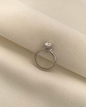 Load image into Gallery viewer, A 1 Carat Round Moissanite with An Enclustered Diamond Collar Set in 14K White Gold.
