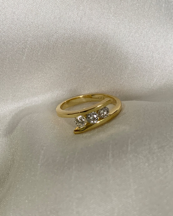 Three stone diamond ring set in 2 diagonal designs in yellow gold.