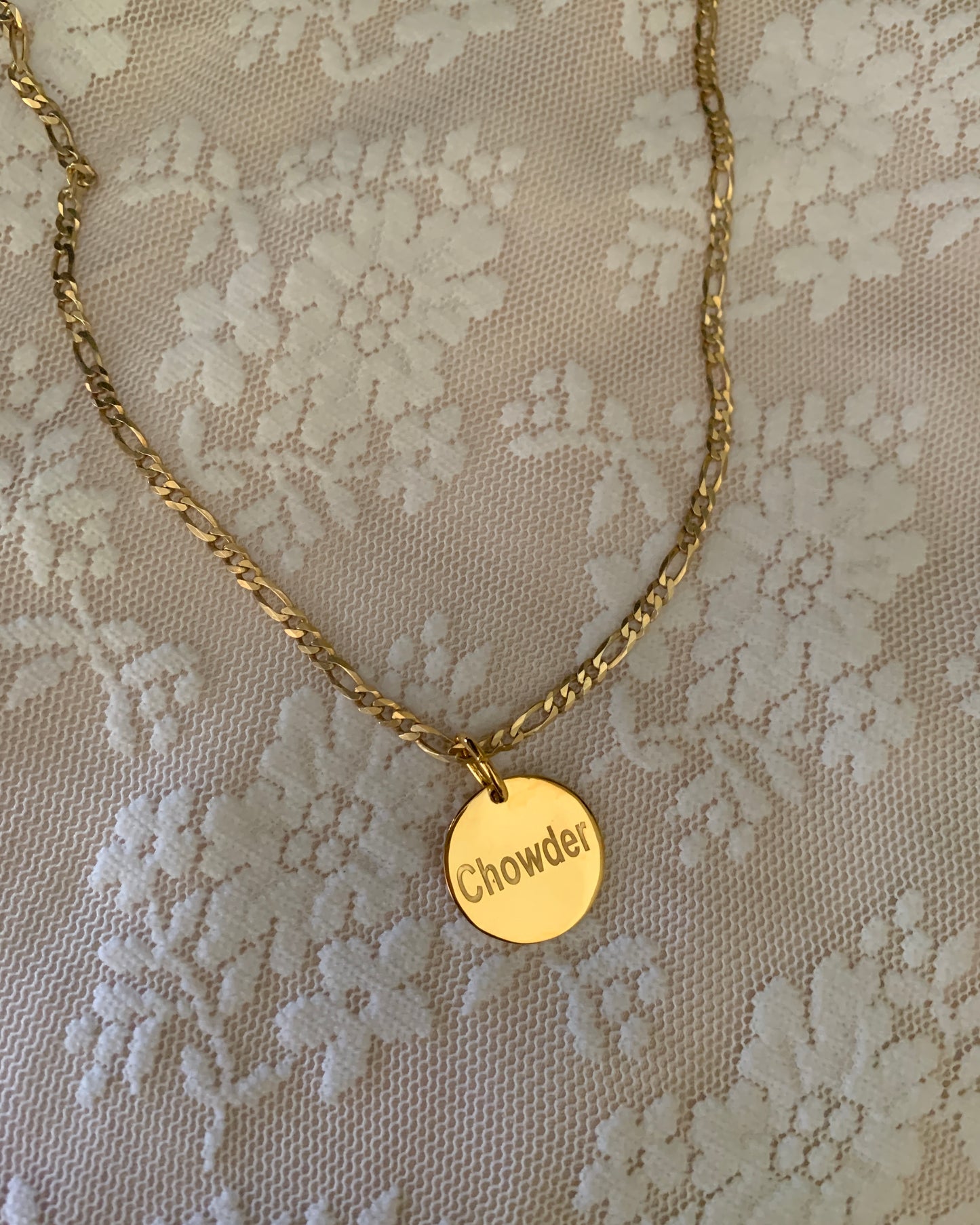 A round yellow gold pendant engraved with the pet's name. With a yellow gold Figaro chain to complete this gorgeous pet tag.