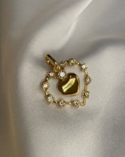 Load image into Gallery viewer, A gold heart pendant with an open heart shaped surrounded by round diamonds.
