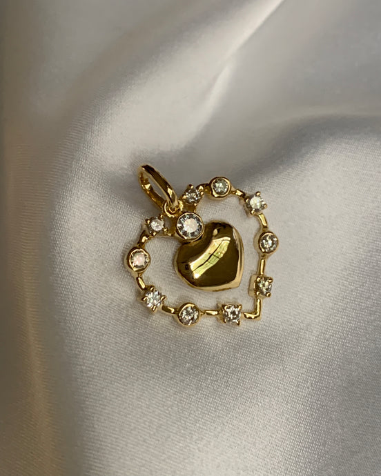 A gold heart pendant with an open heart shaped surrounded by round diamonds.
