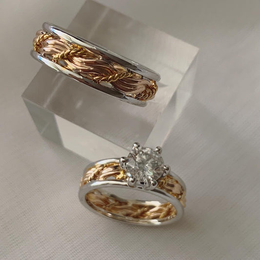 Inspired by the "Cord of Three" bible verse. With three strands set in rose gold and its band set in white gold. For the bride's ring it has a 1 carat moissanite as its center stone.