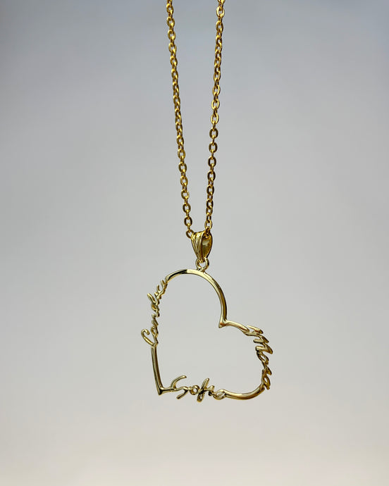 Open heart necklace with three names around it. With a gold argolia to have it hang on a gold chain.