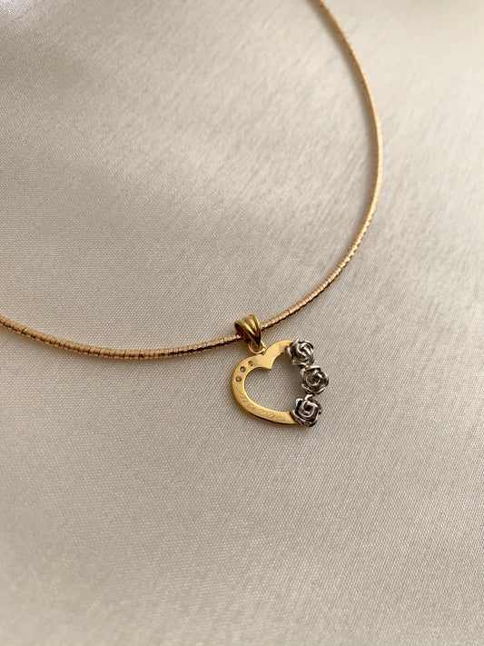 A yellow gold necklace with 3 white gold roses at the side. Alsi with an engraved "nanay" on the other side of the heart.