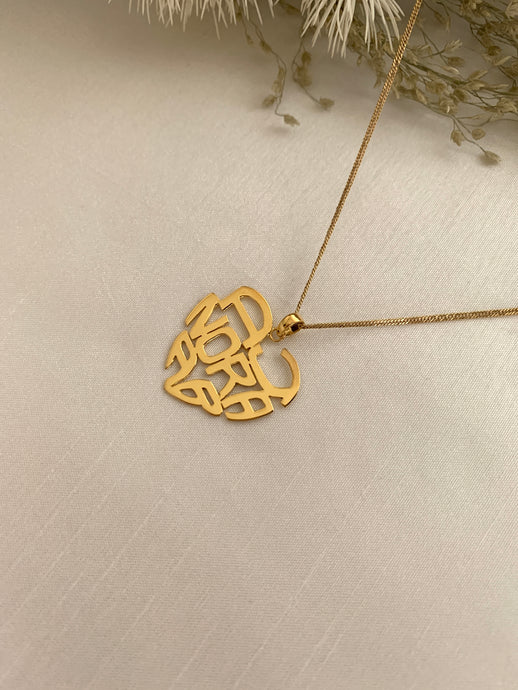 Heart shaped monogram yellow gold necklace. With three names in it.