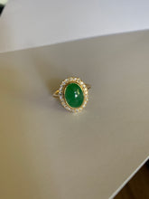 Load image into Gallery viewer, An oval jade stone with diamomd bezzles set in yellow gold.
