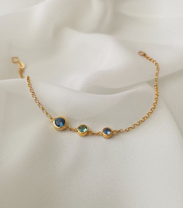 Aquamarine, blue topaz and blue sapphire as center stones of an 18k gold bracelet.