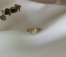 Load image into Gallery viewer, A round diamond enclosed in a 4-claw prong with small sparkling diamonds ,half of the ring. Set in yellow gold.
