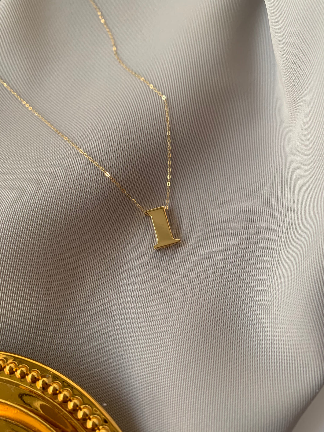 #1 gold pendant and a gold tauco chain.