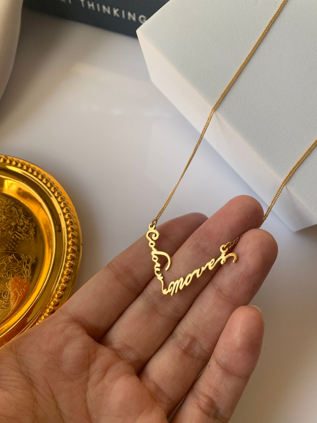 Customized name necklace in V shape. Set in 18k yellow gold.