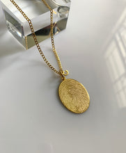 Load image into Gallery viewer, An oval Fingerprint necklace in yellow gold. With an engraved name and a small &quot;C&quot; initial.
