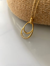 Load image into Gallery viewer, Two intertwined gold oval pendants. With a diamond accent at the center.
