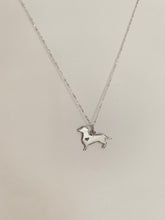 Load image into Gallery viewer, A white gold dog pendant with a heart-shaped stone. 

