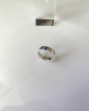 Load image into Gallery viewer, A white gold single band with a textured line at the middle of its thickness. And 2mm princess cut blue sapphires as its center stones.
