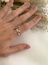 Load image into Gallery viewer, Rose gold and white gold rings stack together with a dual tone diamond ring as its center piece. 
