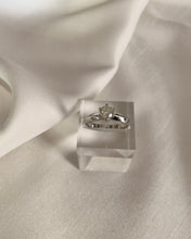 Load image into Gallery viewer, A white gold ring with a knife edge band design with a round diamond as a center stone.
