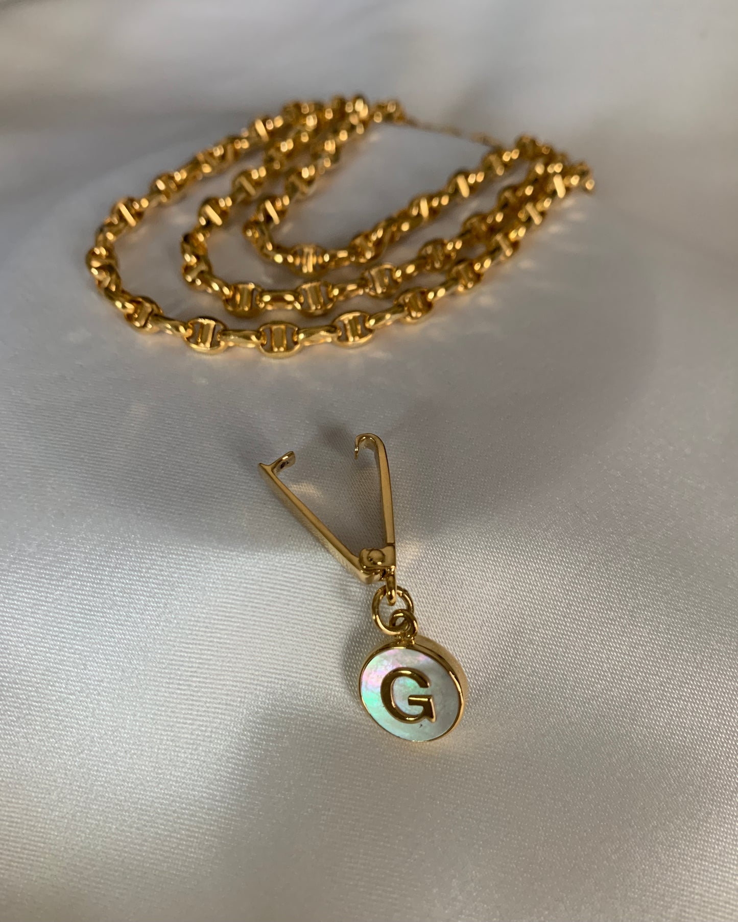 A yellow gold necklace that can be turned into a stylish bracelet too! With an initial G made of mother of pearl.