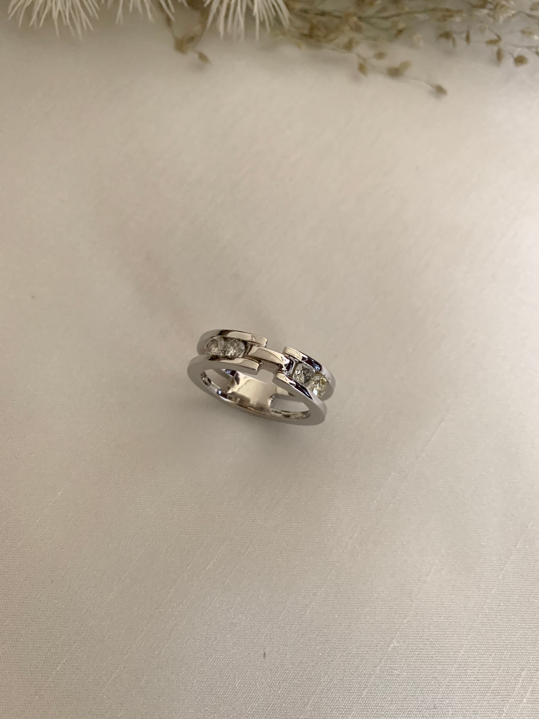4 small round diamonds with a space in between the ring. In white gold setting. 
