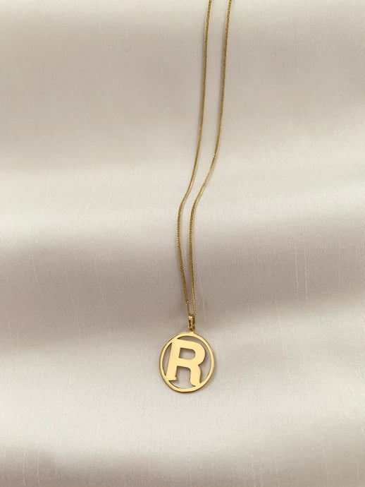 Gold R initial pendant enclosed on an 18k gold too. 